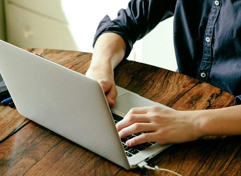 a man sitting at a table using a laptop computer